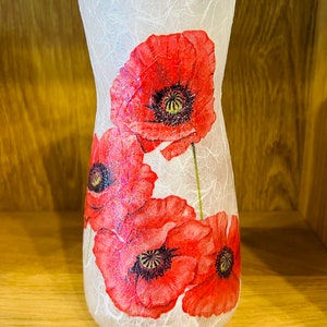May include: A white glass vase with a textured surface and a design of red poppies. The vase is approximately 25 cm tall.