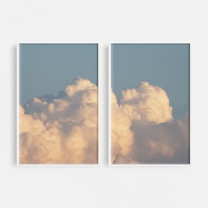 Könnte beinhalten: Zwei gerahmte Fotografien einer großen, flauschigen, weißen Wolke vor einem hellblauen Himmel.