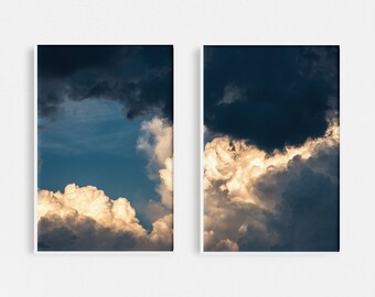 May include: Two framed photographs of a dramatic sky with dark clouds and bright white clouds. The clouds are illuminated by the sun, creating a contrast of light and dark.