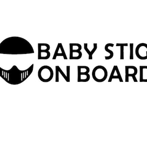 May include: Black and white sticker with a cartoon image of a person wearing a helmet and the text "BABY STIG ON BOARD".