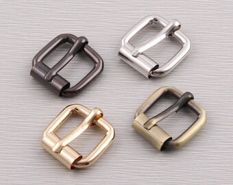 May include: Four metal roller buckles in different finishes: black, silver, gold, and antique brass. Each buckle has a square frame with a roller bar and a pin for securing straps. Ideal for leathercraft and bag making.