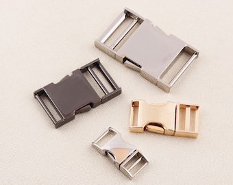 May include: Three metal clasps in different finishes: silver, black, and gold. The clasps are designed for attaching straps or belts.