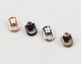 May include: Four metal D-ring hardware pieces in gold, black, silver, and bronze.