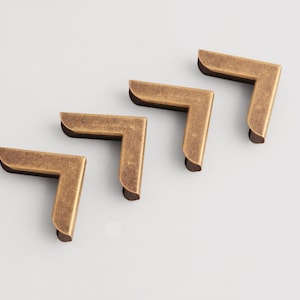 Puede incluir: Una taza de cerámica blanca con un asa negra y el texto "But First, Coffee" en negro, con una fuente de estilo manuscrito. La taza está sobre una superficie blanca.