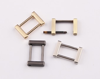 May include: Four metal rectangular buckle clasps in gold, silver, and black. One clasp is disassembled, showing the screw. The clasps have a rectangular bar on each end, connected by two parallel bars.