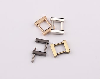 May include: Four metal D-rings in different finishes: gold, silver, black, and antique brass. The rings are all the same size and shape, and they have a square cross-section.