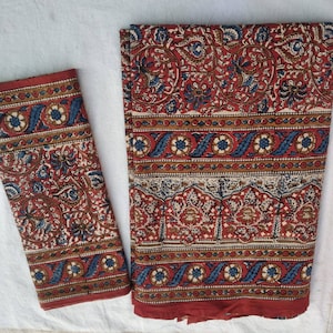 Peut inclure: Un ensemble de deux sets de table en tissu de coton à motifs rouge, bleu et blanc. Les sets de table présentent un motif floral aux détails complexes.