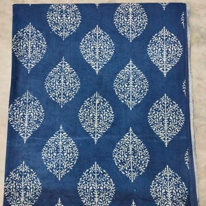 May include: Blue cotton fabric with a white leaf pattern. The fabric is folded in half and has a white border.