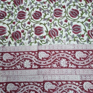 Peut inclure: Tissu blanc avec un motif répété de fleurs bordeaux. Le bas du tissu a une bordure bordeaux avec un motif floral blanc.
