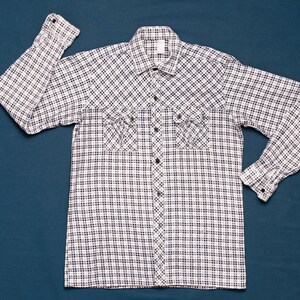 Könnte beinhalten: Ein langärmliges Hemd mit weißen und schwarzen Karos, Knopfleiste und zwei Brusttaschen.