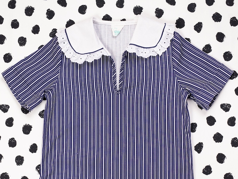 May include: A blue and white striped short-sleeved dress with a white collar and lace trim.