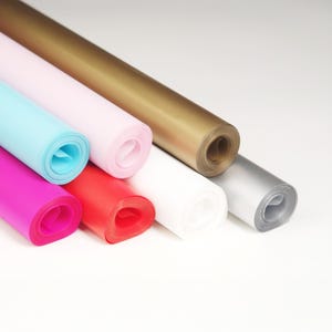 May include: Assortment of rolled tissue paper in various colors, including pink, blue, red, gold, silver, and white.