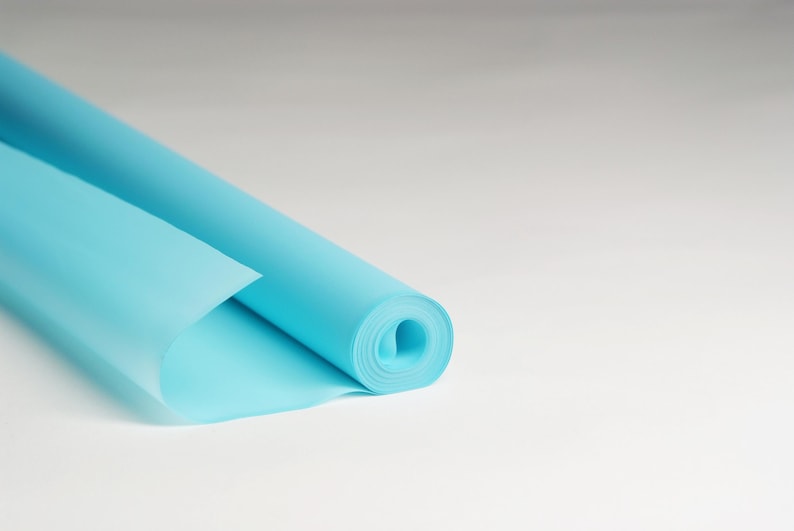 May include: A roll of light blue wrapping paper is partially unrolled, showing the smooth, slightly translucent texture of the paper.