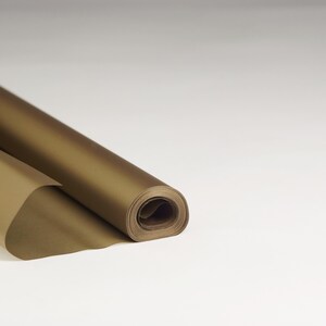 May include: A roll of gold wrapping paper. The paper is rolled up and the end is folded over.