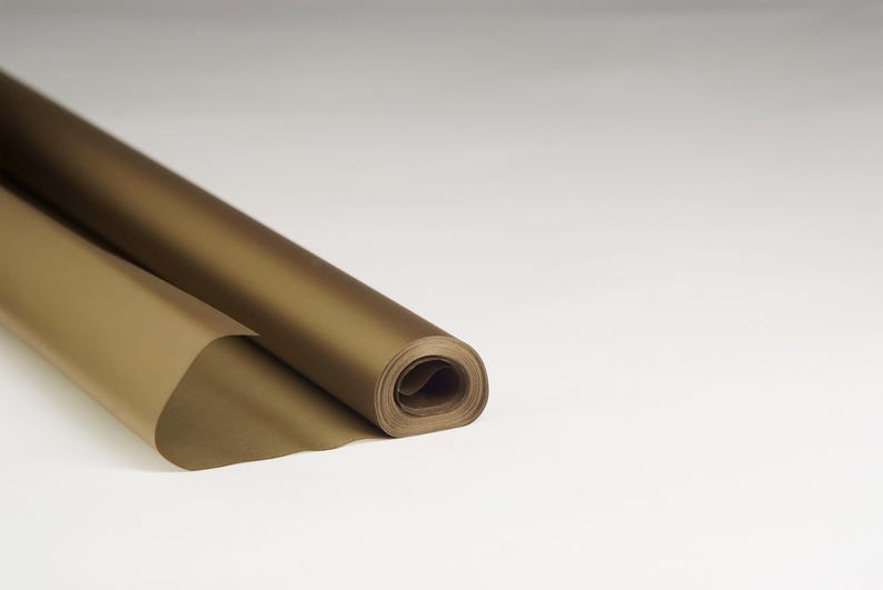 May include: A roll of gold wrapping paper. The paper is rolled up and the end is folded over.