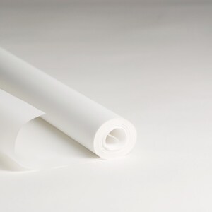 May include: A roll of white paper is partially unrolled, revealing the smooth, white surface of the paper.