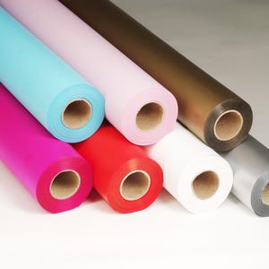 May include: Rolls of colorful wrapping paper in various colors including pink, blue, red, white, silver, and brown.