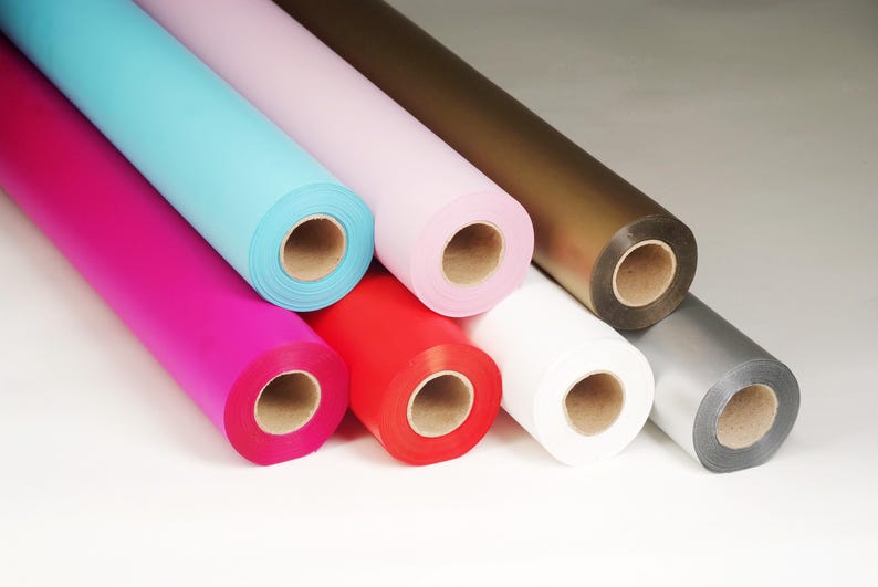 May include: Rolls of colorful wrapping paper in various colors including pink, blue, red, white, silver, and brown.