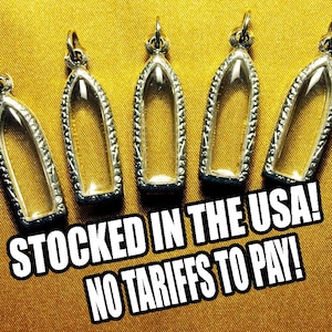 May include: Five silver-toned, empty pendant frames with a clear glass insert, arranged on a gold-colored surface. The frames have a decorative border and a loop for a chain. Text in the image reads: STOCKED IN THE USA! NO TARIFFS TO PAY!