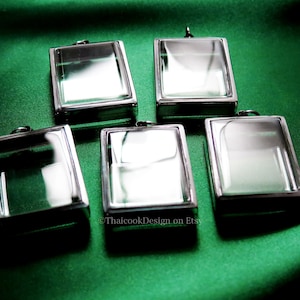 Puede incluir: Cinco marcos de fotos rectangulares plateados con frentes de vidrio transparente. Los marcos tienen un diseño simple y son perfectos para mostrar fotos pequeñas u otros recuerdos.