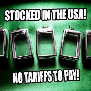 May include: Silver-toned rectangular pendants with clear glass fronts are displayed against a green background. The text "STOCKED IN THE USA!" and "NO TARIFFS TO PAY!" are in white, bold font.