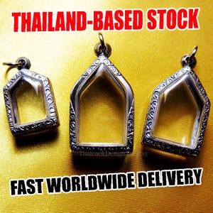 Puede incluir: Tres colgantes plateados vacíos con bordes ornamentados e inserciones de vidrio transparente. Los colgantes tienen forma de casa, con un lazo en la parte superior para una cadena. El fondo es de color dorado texturizado. Texto: "THAILAND-BASED STOCK" y "FAST WORLDWIDE DELIVERY".