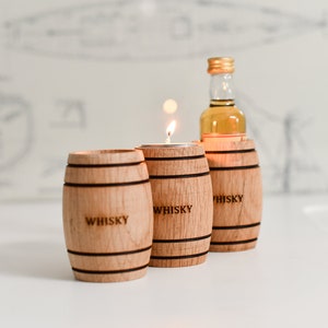 Peut inclure: Trois petits tonneaux en bois avec le mot "WHISKY" gravé dessus. Le tonneau du milieu contient une petite bougie. Une bouteille miniature de whisky est dans le tonneau de droite.