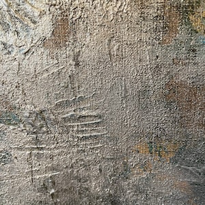 May include: Close-up of a textured, silver-colored canvas surface. The canvas has a rough, uneven texture, with visible brushstrokes and paint splatters. The surface is slightly darker in the lower right corner.