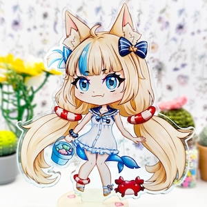 Puede incluir: Figura acrílica de estilo anime de un personaje con cabello rubio, ojos azules y orejas de zorro. La figura lleva un vestido de marinero blanco y sostiene un cubo. También se incluyen brazaletes rojos y blancos y un cangrejo. La base es una escena de playa.