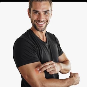 Pu&ograve; includere: Una persona con una maglietta nera indica un segno rosso sul braccio. La persona sorride. Lo sfondo &egrave; bianco.