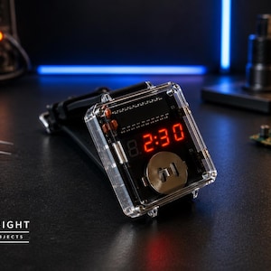 Op de afbeelding: Een digitaal polshorloge met een transparante rechthoekige behuizing, die interne elektronische componenten en een ronde batterij blootlegt. Het horloge heeft een felrood led-display dat 2:30 aangeeft en een zwarte horlogeband.