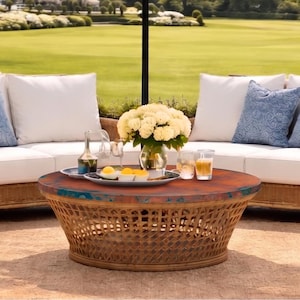 May include: Outdoor patio set with a navy blue and white scalloped umbrella, two sofas, and two armchairs. The furniture is made of woven wicker and has white cushions and blue accent pillows. A round coffee table sits in the center.