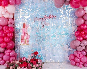 Könnte beinhalten: Eine Geburtstagsfeier-Kulisse mit einer dreistöckigen rosa Torte auf einem transparenten Ständer, umgeben von rosa und roten Luftballons. Ein Blumengesteck aus roten und rosa Rosen befindet sich am Boden, mit dem Schriftzug "Happy Birthday Sienna" in Kursivschrift.
