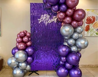 Könnte beinhalten: Party-Dekoration mit einer lila Paillettenwand und einem Neon-Schild mit der Aufschrift "Let's Party". Ballonbögen in Lila, Silber und Burgunderrot schaffen eine festliche Atmosphäre. Ideal für Geburtstage und besondere Anlässe.