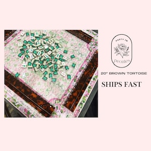 May include: A 20-inch brown tortoise mahjong set with a floral patterned playing surface. The set includes green and white tiles scattered across the board. The image also includes the text "Party in Peonies".
