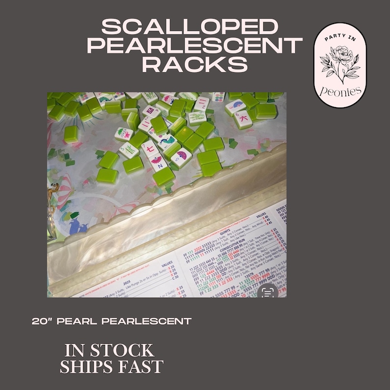 May include: A selection of green and white Mahjong tiles. The image features the text "SCALLOPED PEARLESCENT RACKS" and "20" PEARL PEARLESCENT". The tiles are scattered on a surface. A logo with a floral design is also visible.