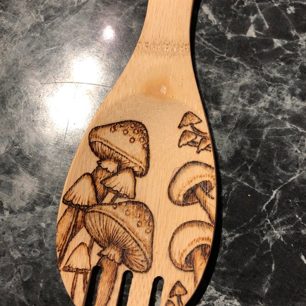 Wood burned spoon with mushroom design.