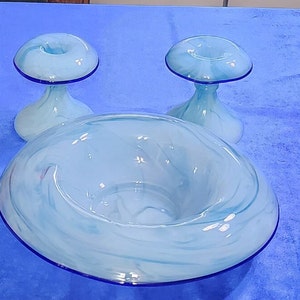 May include: A set of three blue and white glass bowls with a swirl design. The bowls have a blue rim and are perfect for serving snacks or desserts.