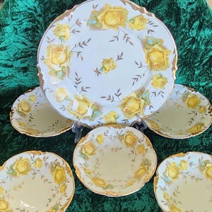 May include: Set of five vintage porcelain plates with a yellow rose pattern. The plates have a white background with gold trim and feature yellow roses with green leaves.