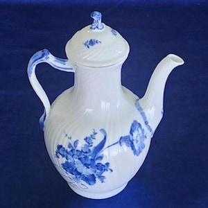 May include: A white porcelain teapot with a blue floral design. The teapot has a lid with a knob on top and a spout on the side. The teapot is decorated with a blue floral pattern.