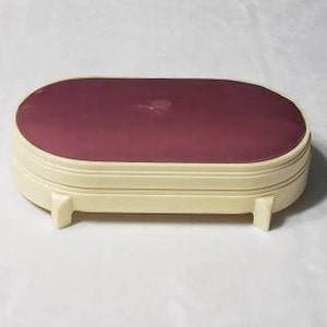 Vintage Deltah Celluloid sieraden of presentatie box. Ovale doos met voeten en stof bedekt deksel met 3 compartimenten binnenin.
