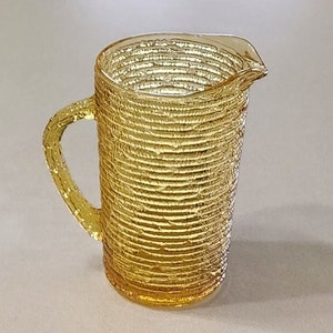 Mid Century Anchor Hocking Soreno 7 inch tall Juice Milk Pitcher in Yellow Amber. Holds about 26 inches. No wear or damage.