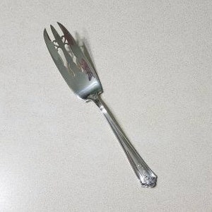 May include: Silver cake server with an ornate design and a pierced blade.