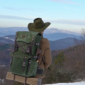 Bushcraft backpack in army green waxed canvas. Customizable pockets and canvas color. Brown leather and solid stainless steel buckles.
