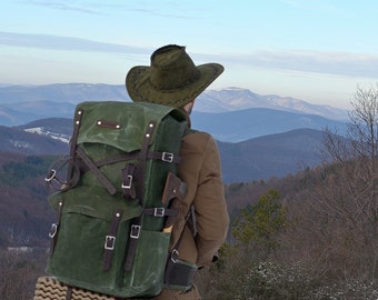 Bushcraft backpack in army green waxed canvas. Customizable pockets and canvas color. Brown leather and solid stainless steel buckles.