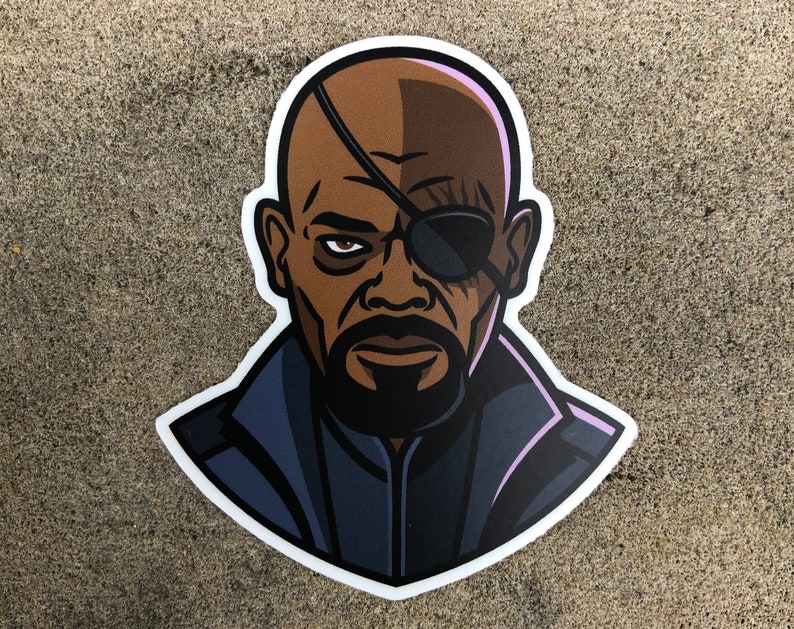 May include: A sticker featuring a stylized illustration of a man with brown skin, a bald head, and an eye patch. He is wearing a dark blue jacket. The sticker has a white border and is placed on a textured gray surface.