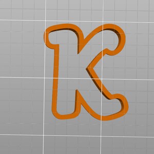 May include: Orange plastic cookie cutter in the shape of the letter K.