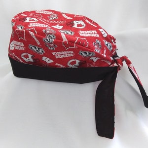 May include: Red and black bandana with a Wisconsin Badgers logo pattern. The bandana has a black band around the edge and ties at the back.