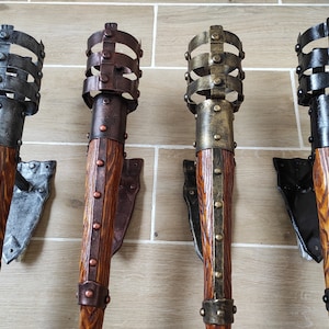 May include: Four decorative wall-mounted torch sconces with metal accents. The sconces are made of wood and have a rustic finish. The sconces are in different colors, including black, brown, and gold.