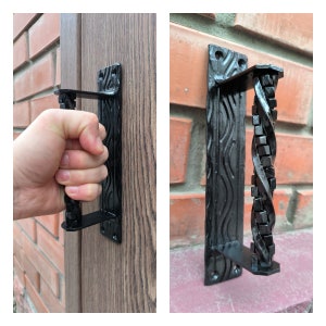 May include: Two black metal door handles with a decorative design. One handle has a twisted metal design and the other has a wavy design.